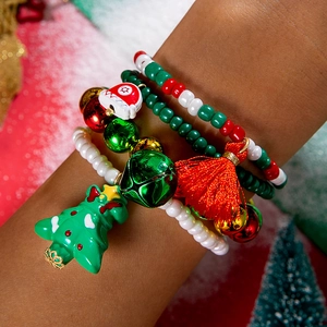 Close-up of Christmas themed red beaded bracelet set with bells and tassels on wrist