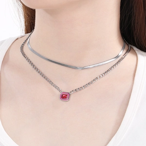 Detail of silver double-layer snake chain with red square gemstone pendant on neck