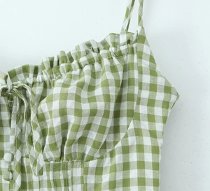 Detailed view of green and white gingham dress with ruched bodice and button accents