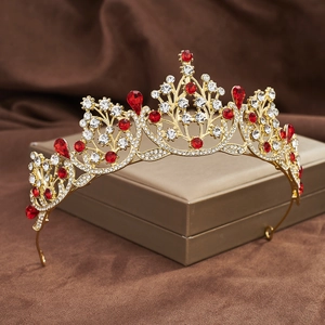 Close-up of golden baroque tiara with red and clear crystals on elegant gift box