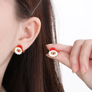 Detail of Christmas Santa Claus enamel stud earrings with red and white oil-drop finish