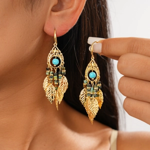 Détails de boucles d'oreilles vintage en or avec perles turquoise et pendentifs feuilles