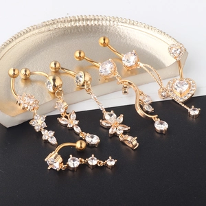 Detail of 5 golden belly rings with zircons on a vintage plate, macro product view