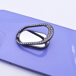 Close-up of a black oval diamond-encrusted metal ring holder on a purple phone case
