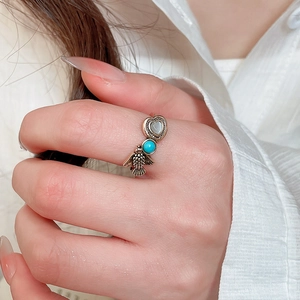 Detail of vintage bronze ring featuring moonlight stone, turquoise and engraved bird design