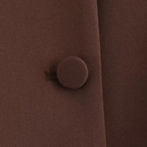 Close-up of deep brown fabric texture with a matching fabric-covered button and buttonhole