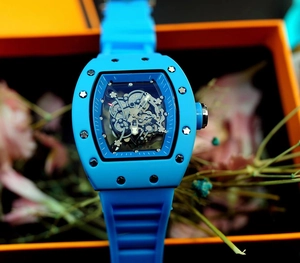 Detailed macro of a blue silicone strap watch with a skeleton dial and tonneau-shaped case