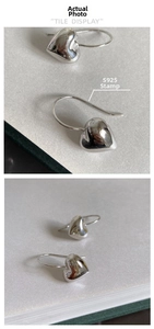 Macro detail of S925 sterling silver stamp and polished 3D heart-shaped hook earrings