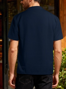 Vue arrière du polo en maille bleu marine montrant le tissu texturé sur un mannequin