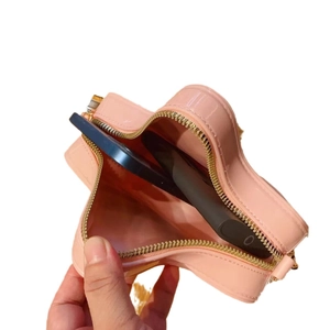 Pink star-shaped patent leather crossbody bag showing internal space for two smartphones