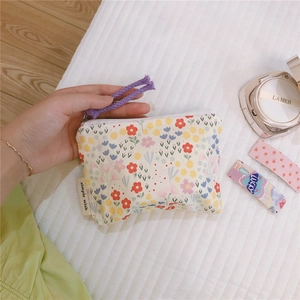 Close-up of floral mini coin purse with zipper closure and simple wish woven label