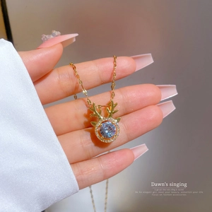 Elegance gold antler pendant necklace with micro-paved cubic zirconia stone held in hand