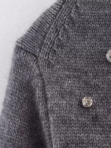 Close-up of grey ribbed knit cardigan with sparkling rhinestone crystal embellishments