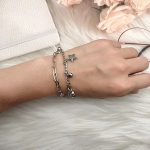 Detail view of double-layer silver star bracelet with bell charm and I love you engraving