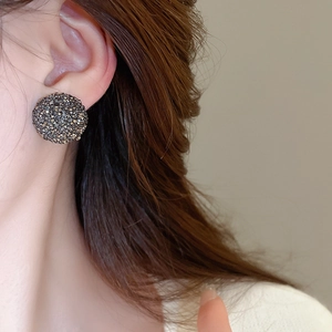 Gros plan d'une boucle d'oreille cœur en argent avec sertissage pavé de diamants