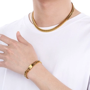 Hip-hop style gold cuban link necklace and bracelet set shown on a male model