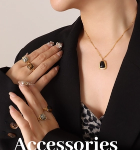 Close-up of gold titanium necklace and rings set featuring colorful cat-eye stone pendants