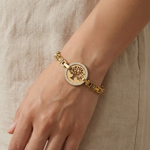 Gros plan du bracelet Arbre de Vie doré avec strass blancs porté par une femme