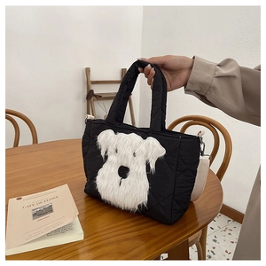 Detail of black quilted children handbag with plush white puppy motif and handle