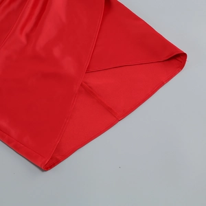 Détail du tissu en satin rouge montrant la texture et la doublure de la robe