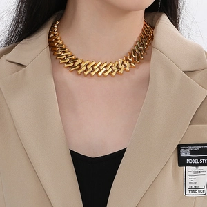 Detailed view of a 20mm chunky gold titanium steel Cuban chain necklace on a model