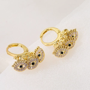 Goldene Creolen im Evil Eye Design mit rosa und schwarzen Zirkoniasteinen auf weiß