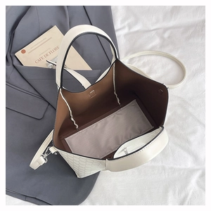 Close-up of beige tote bag with hollowed-out punch pattern and brown inner lining