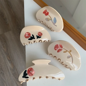Detail of cream flower hair claws with red roses and rhinestones in a four-piece set