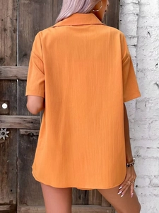 Women orange pleated short sleeve shirt with lapel collar shown in stylish back view