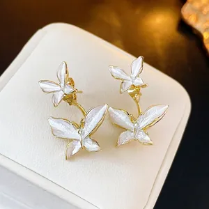Elegant gold-framed double butterfly stud earrings with white pearlescent resin wings