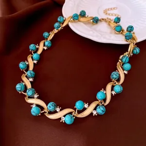 Vintage gold turquoise necklace with diamonds on brown satin and ceramic plate