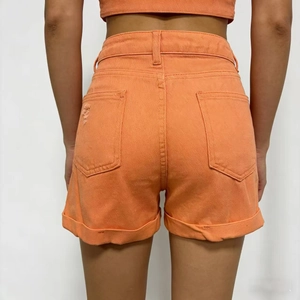 Vista posteriore degli shorts in denim arancione a vita alta con orli sfrangiati e dettagli