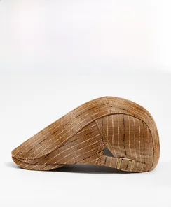 Detail view of the brown vintage flat cap side with bronze buckle and stripe texture