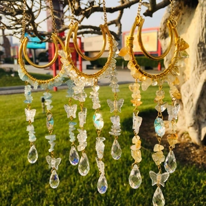 Moon-shaped suncatcher with natural crystal gravel and waterdrop pendants on a tree branch