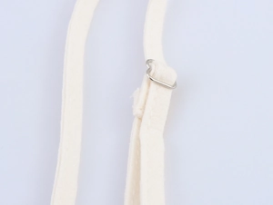 Detailed macro view of adjustable cream cotton shoulder straps with silver metal buckles