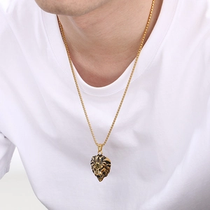 Détail d'un pendentif tête de lion doré style hip hop porté par un mannequin masculin