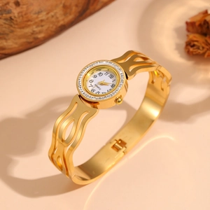 Elegant gold-tone hollow stainless steel bangle watch with a sparkling rhinestone bezel detail