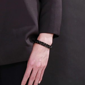 Close-up of a black titanium steel Cuban chain bracelet worn on a man's wrist