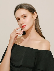 Close-up of a minimalist white ceramic stud earring on model for an elegant daily look