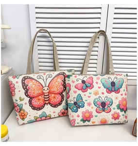 Detail of two canvas tote bags with vibrant butterfly and floral prints and woven handles