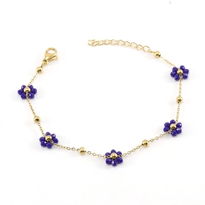 Detail of gold chain bracelet featuring dark blue beaded flowers and adjustable clasp