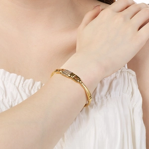 Détail d'un bracelet jonc en acier inoxydable doré 18k ajouré avec oxydes de zirconium