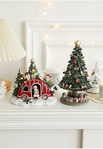 Detailed view of a mini resin Christmas camper and tree with LED festive lights