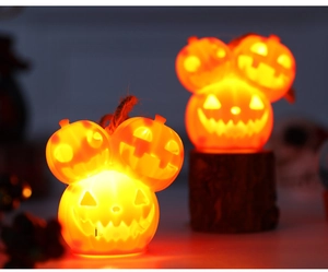 Close-up of triple stacked Halloween pumpkin lights with warm LED glow and rope handle