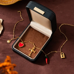 Détail d'un collier plaqué or 18 carats avec breloques dans son coffret cadeau de luxe.