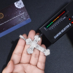 Macro shot of S925 silver moissanite cross pendant with GRA certificate and diamond tester