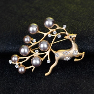 Detailed view of a golden reindeer brooch adorned with grey pearls and shiny rhinestones