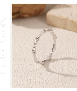 Macro shot of silver S925 bamboo joint ring texture on a minimalist stone surface