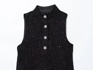 Detail der schwarzen Tweed-Weste mit Pailletten und funkelnden Strassknöpfen auf Weiß