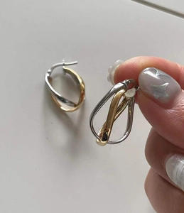 Detail shot of 925 sterling silver mermaid bicolor hoop earrings with gold and silver intertwining